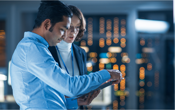 Two employees working on a tablet in a data center
